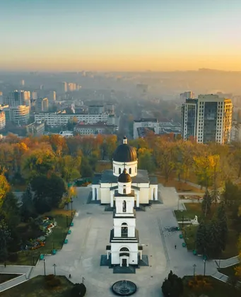 Luchtfoto van Chișinău bij zonsopgang met de witte kathedraal en het park in herfstkleuren